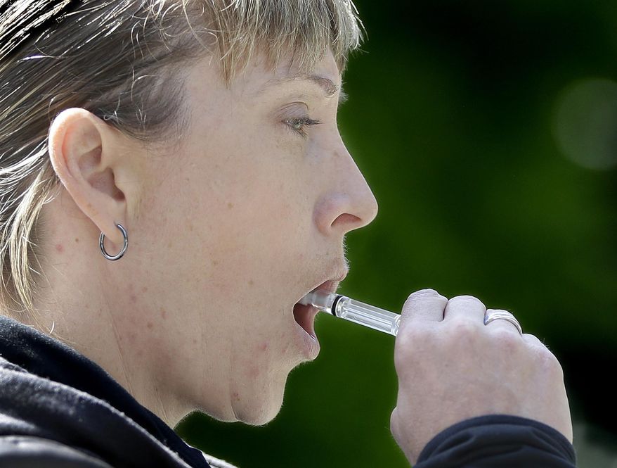 California Highway Patrol Sgt. Jaimi Kenyon, swabs the inside of her mouth to collect saliva during a demonstration of drug testing device Wednesday, May 10, 2017, in Sacramento, Calif. Three of California's largest counties are testing a device that can detect the presence of drugs in saliva within five minutes. Some officers and lawmakers want the devices used statewide after voters passed Proposition 64 in November, legalizing the recreational use of marijuana. (AP Photo/Rich Pedroncelli)