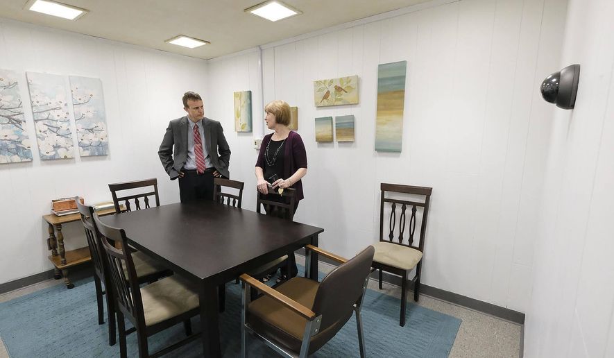 In this April 17, 2017 photo, Saline County State's Attorney Jayson Clark, left, and Sheryl Woodham, executive director of the Guardian Center, discuss the interview room that is often used for young witnesses to testify via closed circuit television at the Saline County Courthouse in Harrisburg, Ill. Woodham and Saline County Sheriff Keith Brown turned an old office used by the sheriff's office for storage into a child-friendly room that would allow a child to wait in comfort and testify in that same room. (Byron Hetzler/The Southern, via AP)