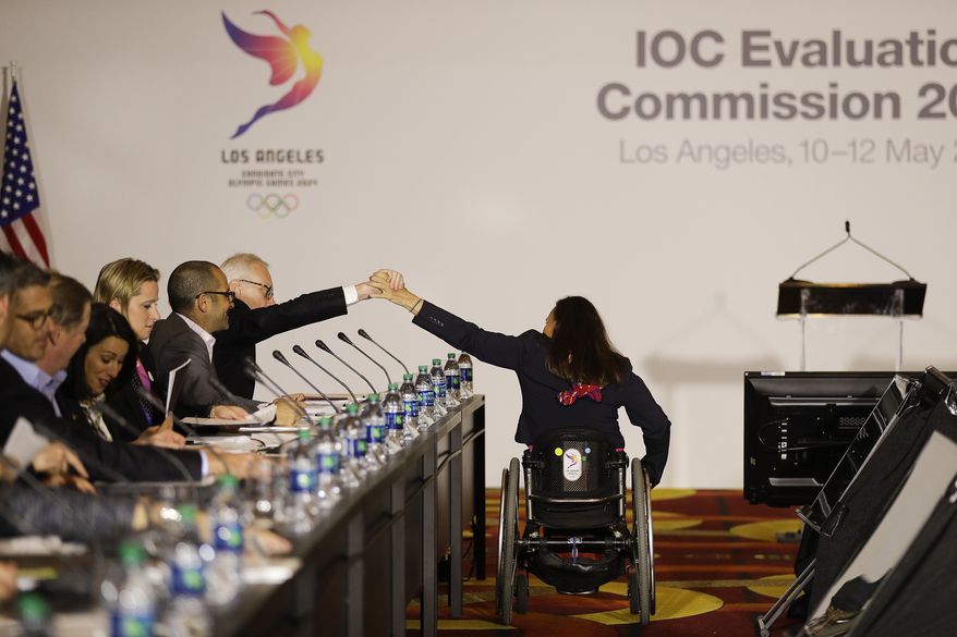 Paralympian Candace Cable, center, high-fives Los Angeles 2024 committee members at an evaluation session with the International Olympic Committee's Evaluation Commission Wednesday, May 10, 2017, in Los Angeles. (AP Photo/Jae C. Hong)