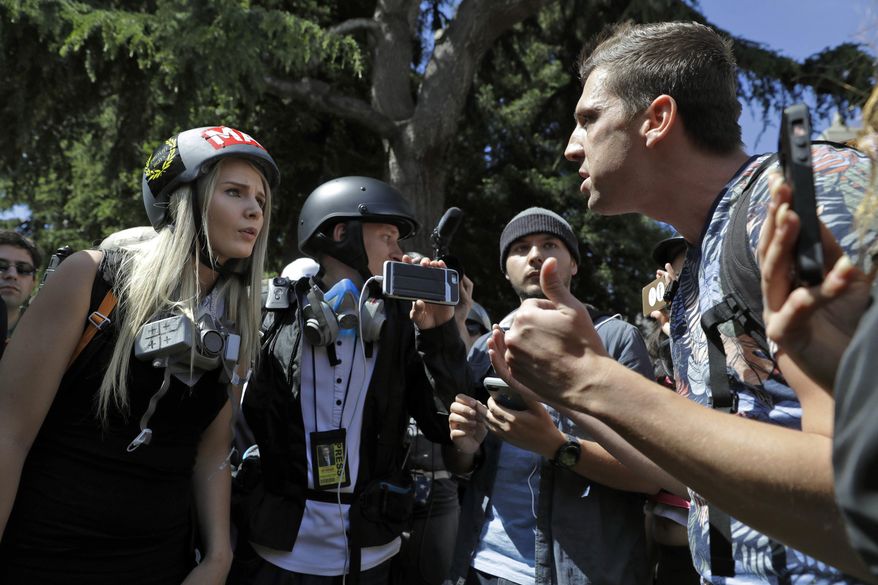 FILE - In this April 27, 2017 file photo, demonstrators, sharing opposing views, argue during a rally in Berkeley, Calif., near the University of California, Berkeley campus, to show support for free speech and to condemn the views of Ann Coulter and her supporters. Coulter's speech was cancelled. Since the beginning of 2016, more than two dozen campus speeches have been derailed amid controversy, according to the Foundation For Individual Rights In Education, a group that monitors free speech on campuses. (AP Photo/Marcio Jose Sanchez, File)
