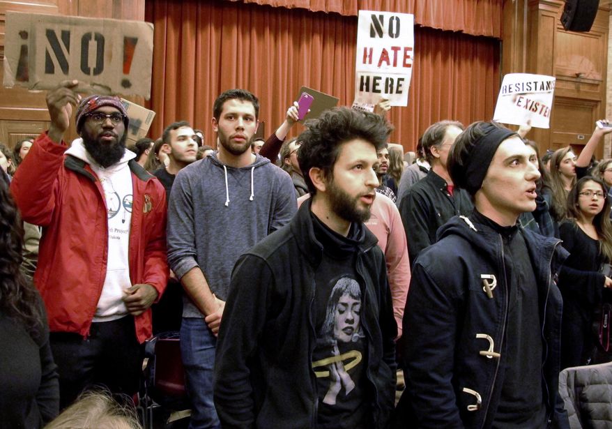 FILE - In this March 2, 2017, file photo, Middlebury College students turn their backs to Charles Murray, unseen, during his lecture in Middlebury, Vt. Hundreds of students protested his lecture, forcing the college to move his talk to an undisclosed campus location from which it was live-streamed to the original venue. Since the beginning of 2016, more than two dozen campus speeches have been derailed amid controversy, according to the Foundation For Individual Rights In Education, a group that monitors free speech on campuses. (AP Photo/Lisa Rathke, File)