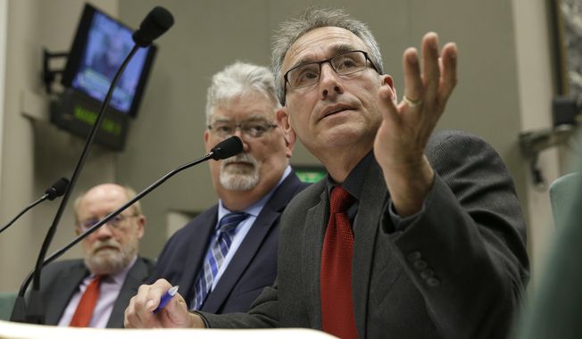 David Gutierrez, a consultant for the Department of Water Resources., answers a lawmaker&#x27;s questions concerning the damaged spillways of the Oroville Dam during a joint Assembly committee hearing Thursday, May 11, 2017, in Sacramento, Calif. Lawmakers cited emerging technical reports from two independent teams of experts on the Oroville Dam&#x27;s two spillway&#x27;s, citing concrete that was thinner than modern standards call for, cracks, tree roots that had blocked spillway drains and bedrock anchoring the dam that was far weaker then assumed as some of the reasons for the near collapse of the spillways that caused the evacuation of nearly 200,000 people downstream of the Oroville Dam in February. At left is Resources Secretary John Laird, in the center is Bill Croyle, acting Director of the California Department of Water Resources. (AP Photo/Rich Pedroncelli)