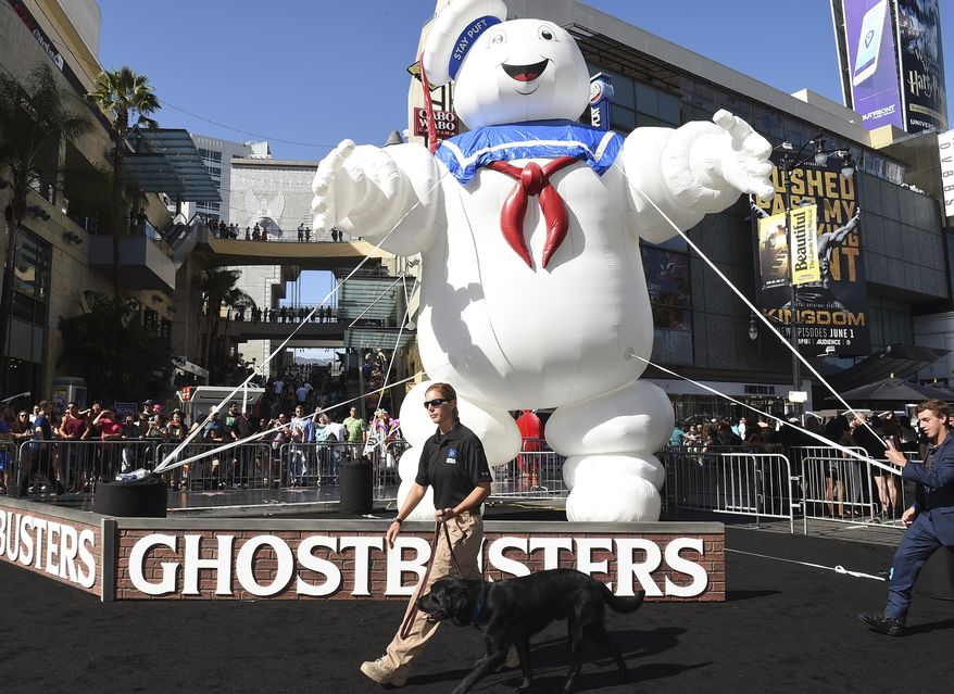FILE - In this , July 9, 2016, file photo, a K-9 dog and handler walk past a balloon Stay Puft Marshmallow Man at the Los Angeles premiere of "Ghostbusters" at the TCL Chinese Theatre. Scientists in Canada announced on May 9, 2017, that they named a newly-identified dinosaur after Zuul, a monster from the original “Ghostbusters” film. (Photo by Jordan Strauss/Invision/AP, File)