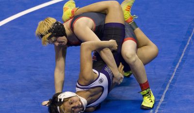 FILE - In this Feb. 25, 2017, file photo, Euless Trinity&#39;s Mack Beggs, top, drives Morton Ranch&#39;s Chelsea Sanchez against the mat during the girls Class 6A 110-pound championship final at the UIL state wrestling championships in Cypress, Texas. When Texas transgender wrestler Mack Beggs won a girls’ state championship, his victory drew jeers and complaints that his steroid therapy treatment had given him an unfair advantage against girls who risked injury just by getting on the mat with him, Now state lawmakers are pushing a bill that could deny Beggs, a Dallas area-junior, a chance to defend his title. (Jason Fochtman/Houston Chronicle via AP, File)