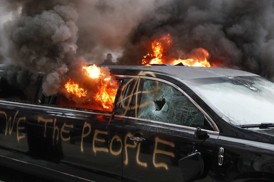 A parked limousine burns during a demonstration after the inauguration of President Donald Trump, Friday, Jan. 20, 2017, in Washington. (AP Photo/John Minchillo) ** FILE **