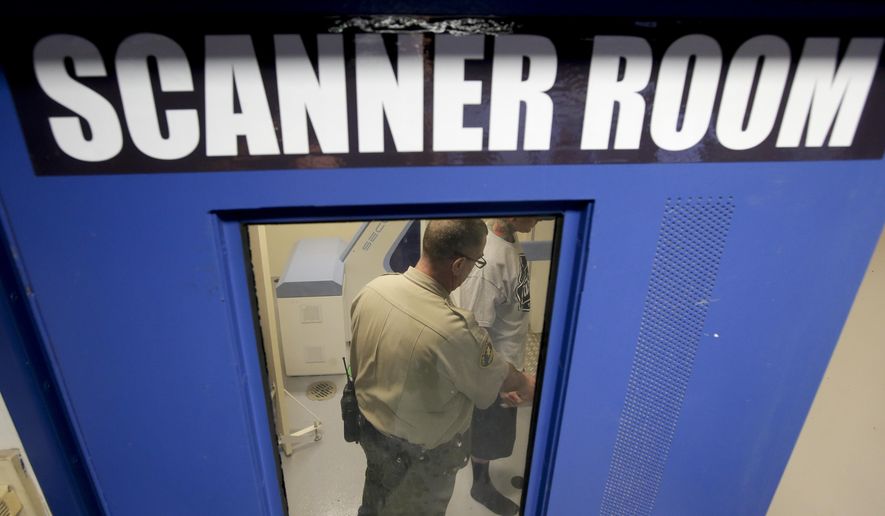 FILE - In this Nov. 20, 2014, file photo, Deputy Robert J. Rudisill takes a prisoner though a body scan after being taken into custody at San Diego County sheriffís Vista Detention Center in Vista, Calif. A study has found mixed results from the $15 million California spent to thwart prison drug smuggling by increasingly creative inmates. Researchers from the University of California, Berkeley, and the Public Policy Institute of California said smugglers use tricks like concealing methamphetamine in a bar of soap or heroin on the backs of postage stamps. (AP Photo/Chris Carlson, File)