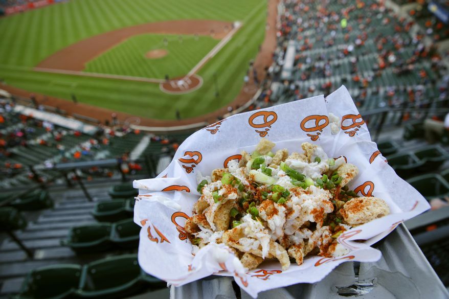 This May 8, 2017, photo shows a Crabmeat Pork Rind Chipper at Oriole Park at Camden Yards before a baseball game between the Washington Nationals and the Baltimore Orioles in Baltimore. It contains pork rinds topped with cheese sauce, crab meat, Old Bay seasoning, and scallions. (AP Photo/Patrick Semansky)