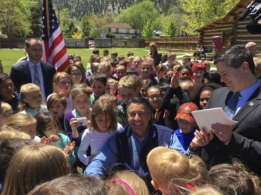 Nevada Gov. Brian Sandoval smiles after signing Assembly Bill 385 expanding free parks admission for elementary students at Mormon Station State Historic Park in Genoa, Nev., Friday, May 12, 2017. Under the law, Nevada students ages 9-11 can play at state parks for free beginning in July. The measure builds on a federal program that allows fourth-graders to apply for free admission to all national parks and Nevada state parks. (AP Photo/Alison Noon)