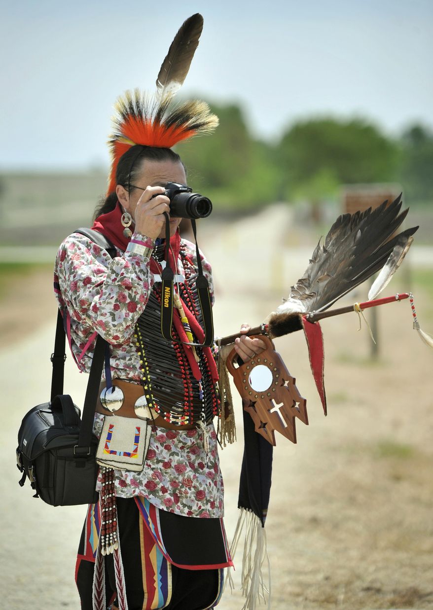 Monte Harris, of Ponca City, Oklahoma, takes a photo as he stands on a section of trail during a ceremony Thursday, May 11, 2017 in which the Nebraska Trails Foundation formally turned over nearly 20 miles of recreational trail between Beatrice and the Kansas State Line to the Ponca Tribe of Nebraska. The section will now be called the Chief Standing Bear Trail. (Eric Gregory/The Journal-Star via AP)