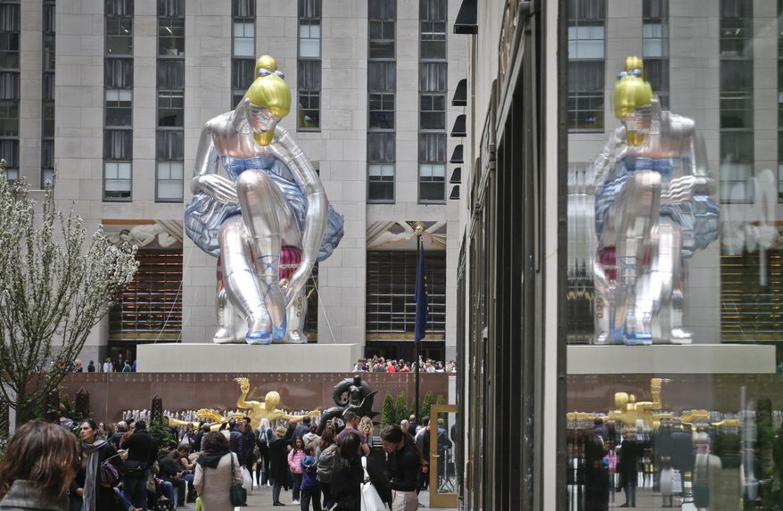 &amp;quot;Seated Ballerina&amp;quot;, center, the public art exhibition of a 45-foot tall inflatable nylon sculpture depicting a seated ballerina from artist Jeff Koons&#39; Antiquity series, is displayed at Rockefeller Center after it was unveiled Friday May 12, 2017, in New York. (AP Photo/Bebeto Matthews).