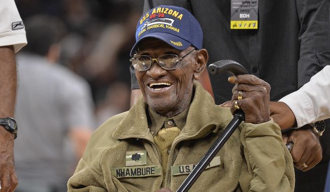 In this March 23, 2017, file photo, Richard Overton leaves the court after a special presentation honoring him as the oldest living American war veteran, during a timeout in an NBA basketball game between the Memphis Grizzlies and the San Antonio Spurs. Overton was honored by his hometown of Austin, Texas, on his 111th birthday on May 11, 2017. (AP Photo/Darren Abate, File)
