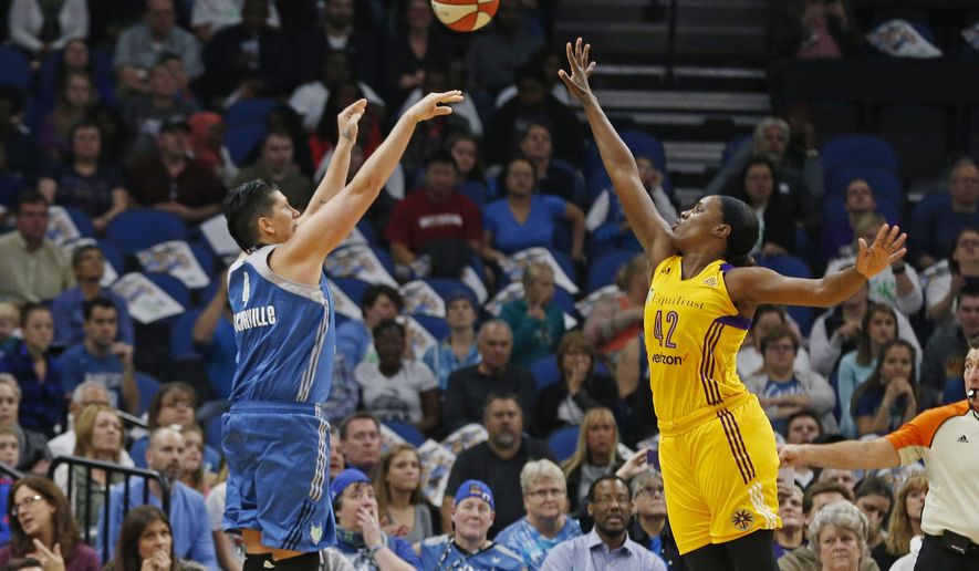 FILE - In this Oct. 11, 2016, file photo, Minnesota Lynx's Janel McCarville shoots and scores over Los Angeles Sparks' Jantel Lavender during the first quarter of Game 2 of the WNBA basketball finals in Minneapolis. Coming off one of the most successful seasons in WNBA history on and off the court, the league has found ways to try to bring in new fans. Whether streaming games on Twitter, partnering with FanDuel to offer daily fantasy sports or just having more games on television, the WNBA is growing. (AP Photo/Jim Mone, File)