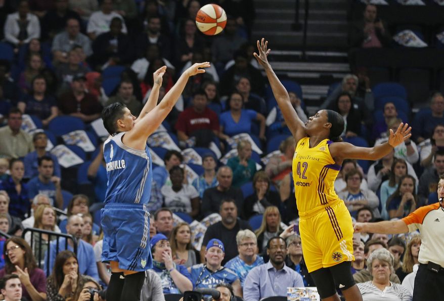 FILE - In this Oct. 11, 2016, file photo, Minnesota Lynx's Janel McCarville shoots and scores over Los Angeles Sparks' Jantel Lavender during the first quarter of Game 2 of the WNBA basketball finals in Minneapolis. Coming off one of the most successful seasons in WNBA history on and off the court, the league has found ways to try to bring in new fans. Whether streaming games on Twitter, partnering with FanDuel to offer daily fantasy sports or just having more games on television, the WNBA is growing. (AP Photo/Jim Mone, File)