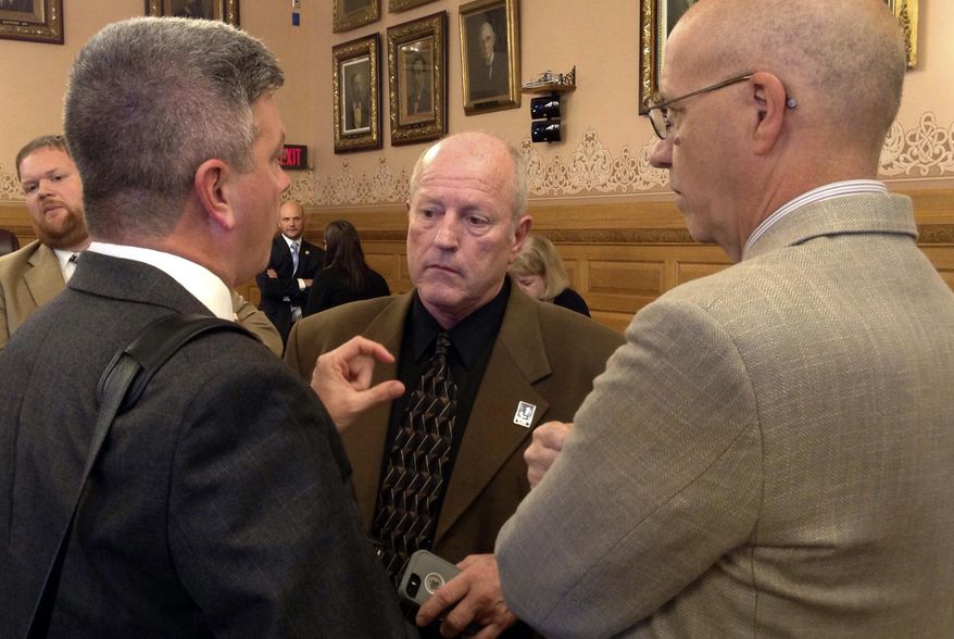 Kansas state Rep. Larry Campbell, center, R-Olathe, the chairman of a House committee on school finance issues, confers with former state Sen. Jeff King, left, and J.G. Scott, right, the chief fiscal analyst for the Legislature's research staff, Friday, May 12, 2017, at the Statehouse in Topeka, Kan. King, an attorney, is advising lawmakers as they draft an education funding plan to satisfy a state Supreme Court ruling (AP Photo/John Hanna)