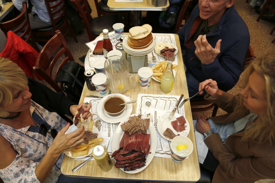 Diners enjoy eating at Katz's Delicatessen in New York, Thursday, May 11, 2017. The famed New York City restaurant that made a name for itself during World War II with the slogan "send a salami to your boy in the Army," is launching an expanded global delivery business that will allow people to ship its cured meats around the world. (AP Photo/Seth Wenig)