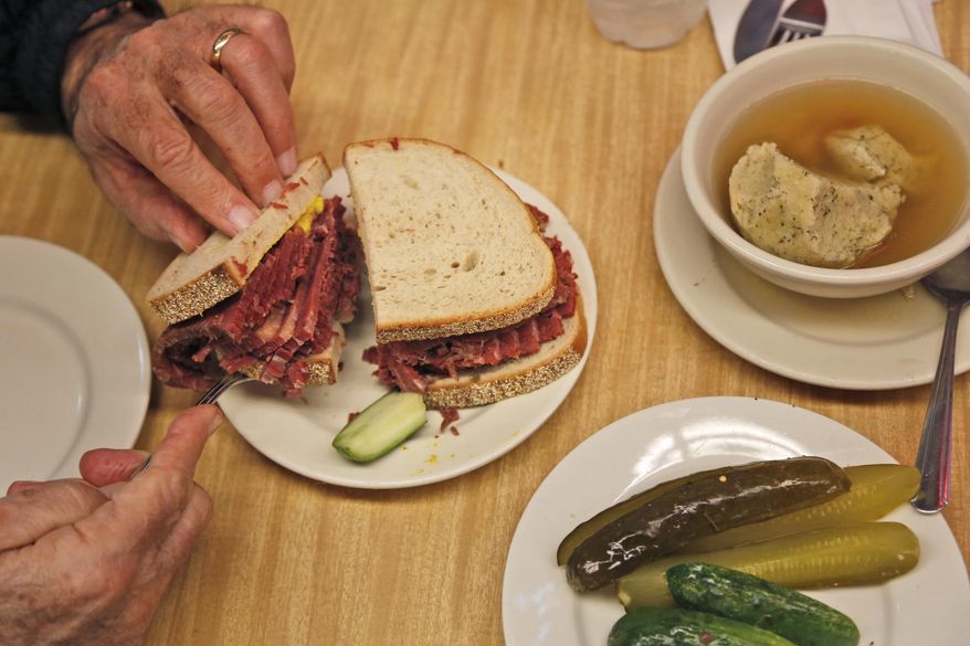 Diners enjoy eating at Katz's Delicatessen in New York, Thursday, May 11, 2017. The famed New York City restaurant that made a name for itself during World War II with the slogan "send a salami to your boy in the Army," is launching an expanded global delivery business that will allow people to ship its cured meats around the world. (AP Photo/Seth Wenig)