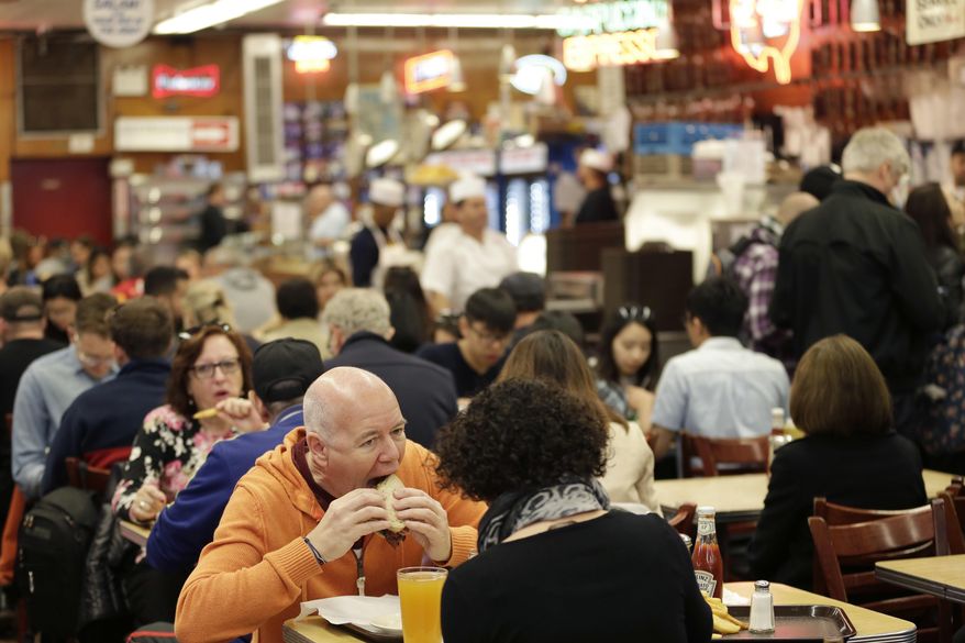 Diners enjoy eating at Katz's Delicatessen in New York, Thursday, May 11, 2017. The famed New York City restaurant that made a name for itself during World War II with the slogan "send a salami to your boy in the Army," is launching an expanded global delivery business that will allow people to ship its cured meats around the world. (AP Photo/Seth Wenig)