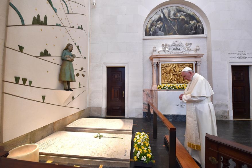 Pope Francis prays at the grave site of Jacinta and Francisco Marto at the Sanctuary of Our Lady of Fatima, Saturday, Friday, May 13, 2017, in Fatima, Portugal. Pope Francis urged Catholics on Friday to "tear down all walls" and spread peace as he traveled to this Portuguese shrine town to canonize two poor, illiterate shepherd children whose visions of the Virgin Mary 100 years ago marked one of the most important events of the 20th-century Catholic Church. (L'Osservatore Romano/Pool Photo via AP)