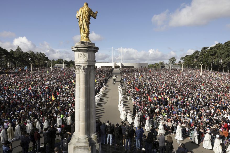 The statue of Our Lady of Fatima is carried in a procession for a Mass celebrated by Pope Francis where he will canonize shepherd children Jacinta and Francisco Marto at the Sanctuary of Our Lady of Fatima, Saturday, Friday, May 13, 2017, in Fatima, Portugal. Pope Francis urged Catholics on Friday to "tear down all walls" and spread peace as he traveled to this Portuguese shrine town to canonize two poor, illiterate shepherd children whose visions of the Virgin Mary 100 years ago marked one of the most important events of the 20th-century Catholic Church. (Paulo Novais/Pool Photo via AP)
