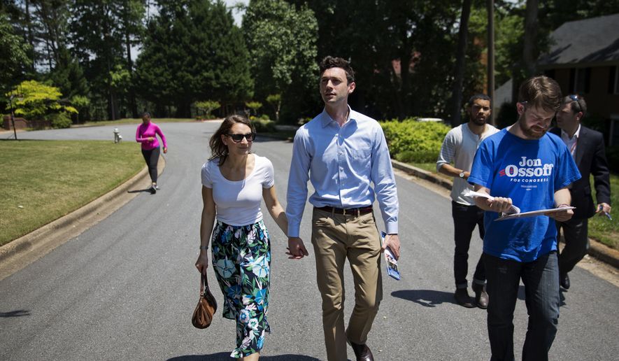 Jon Ossoff, center, a 30-year-old Democrat running for Congress in Georgia&#39;s traditionally conservative 6th Congressional District, and fiancee Alisha Kramer, left, walk with organizer Eliot Beckham, right, while campaigning in Sandy Springs, Ga., Thursday, May 11, 2017. (AP Photo/David Goldman) ** FILE **