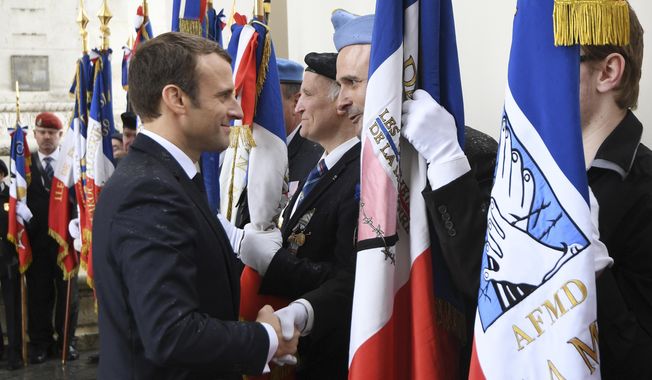 French President Emmanuel Macron greets veterans at the the Unknown Soldier&#x27;s tomb under the Arc de Triomphe after his formal inauguration ceremony as French President Sunday, May 14, 2017 in Paris. Macron was inaugurated as France&#x27;s new president at the Elysee Palace in Paris, and immediately launched into his mission to shake up French politics, world economics and the European Union. (Alain Jocard, Pool via AP)