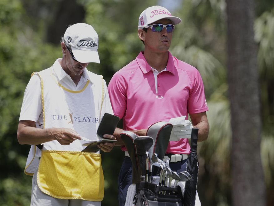 Rafa Cabrera Bello, right, of Spain, looks from the second tee during the final round of The Players Championship golf tournament Sunday, May 14, 2017, in Ponte Vedra Beach, Fla. Caddie Colin Byrne, left, stands by. (AP Photo/Lynne Sladky)