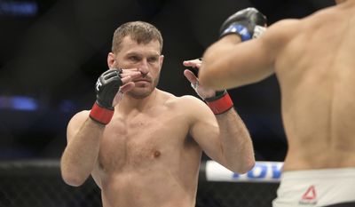 Stipe Miocic, left, fights Junior Dos Santos in a mixed martial arts bout at UFC 211 for the UFC heavyweight championship, Saturday, May 13, 2017, in Dallas. Miocic retained his heavyweight title with a first-round win. (AP Photo/Gregory Payan)
