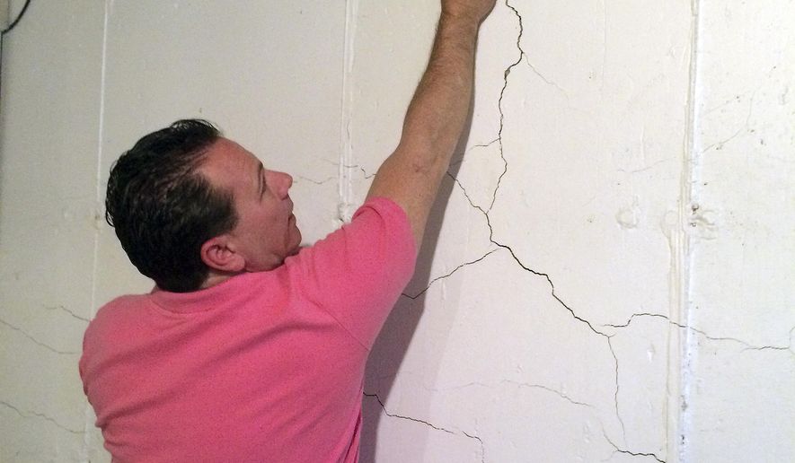 In this April 11, 2017 photo, Tim Heim, a founder of the Connecticut Coalition Against Crumbling Basements, points out damage in his basement foundation due potentially to the presence of the mineral pyrrhotite in the concrete in Willington, Conn. Home foundations in that part of the state are failing because of the mineral, and a growing number of homeowners are seeking financial relief from their town. (AP Photo/Susan Haigh)