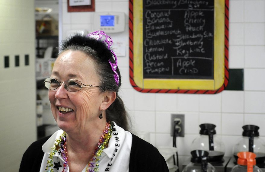 In this April 21, 2017 photo, Connie Suprenant, wearing a tiara that says, "Retired" smiles as a customer at the Blues Cafe in Kankakee wishes her well in retirement. After 40 years, with pitcher of water in one hand and iced tea in the other, on Suprenant's last day, the restaurant was busy, with customers coming in to say goodbye, and to leave balloons and flowers. (Mike Voss/The Daily Journal via AP)