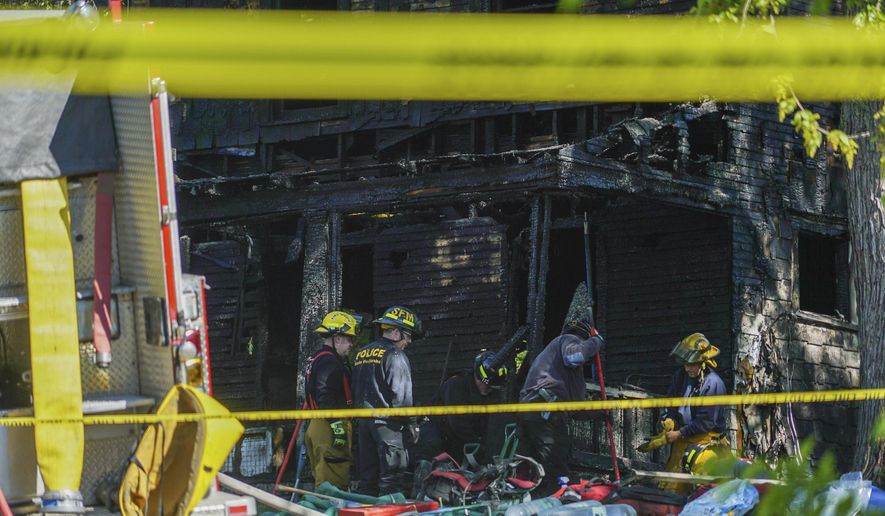 Firefighters investigate the remains of a burned home in Akron, Ohio on Monday, May 15, 2017. Firefighters said multiple people died in the fire at the home. (AP photo/Dake Kang)