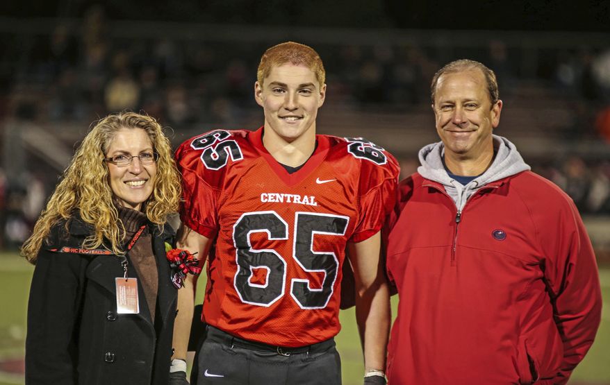 FILE-This Oct. 31, 2014, file photo provided by Patrick Carns shows Timothy Piazza, center, with his parents Evelyn Piazza, left, and James Piazza, right, during Hunterdon Central Regional High School football's "Senior Night" at the high school's stadium in Flemington, N.J. Eighteen members of the now-shuttered Beta Theta Pi fraternity at Penn State University face charges in connection with the Feb. 4 death of sophomore Timothy Piazza of Lebanon, New Jersey. (Patrick Carns via AP, FILE)