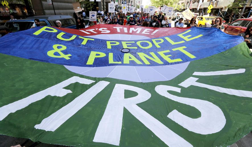 Protesters march with a large parachute banner during the beginning of a march to Springfield, Ill., protesting the state's budget crisis Monday, May 15, 2017, in Chicago. Organizers say the 200 mile trip is scheduled to take 15 days with about 100 people going the distance. (AP Photo/Charles Rex Arbogast)