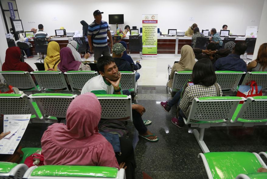 Patients wait at the registration desks at Dharmais Cancer Hospital in Jakarta, Indonesia, Monday, May 15, 2017. Global cyber chaos was spreading Monday as companies booted up computers at work following the weekend's worldwide "ransomware" cyberattack. The extortion scheme created chaos in 150 countries and could wreak even greater havoc as more malicious variations appear. (AP Photo/Dita Alangkara)