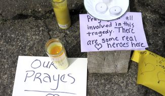 Well-wishing messages and candles for an injured employee are shown outside a grocery store in Estacada, Ore., Monday, May 15, 2017. Police say a man carrying what appeared to be a human head stabbed an employee at the grocery store. (AP Photo/Gillian Flaccus)