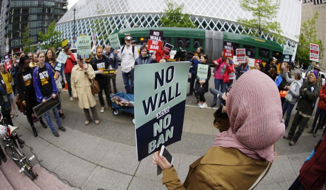 Isra Ayesh, right, of Seattle, who is the organizing director of Americans for Refugees and Immigrants, leads a chant during a demonstration against President Donald Trump&#x27;s revised travel ban, Monday, May 15, 2017, outside a federal courthouse in Seattle. A three-judge panel of the 9th U.S. Circuit Court of Appeals heard arguments Monday in Seattle over Hawaii&#x27;s lawsuit challenging the travel ban, which would suspend the nation&#x27;s refugee program and temporarily bar new visas for citizens of Iran, Libya, Somalia, Sudan, Syria and Yemen. (AP Photo/Ted S. Warren)