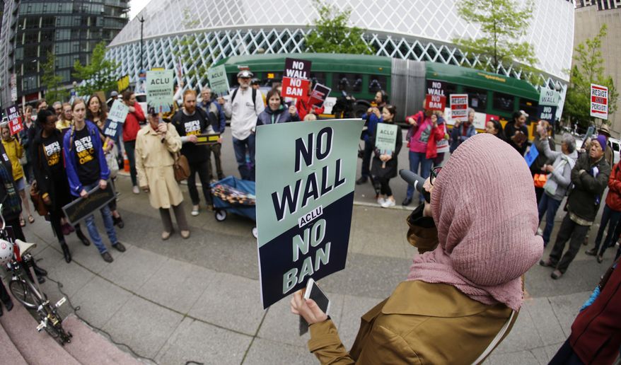 Isra Ayesh, right, of Seattle, who is the organizing director of Americans for Refugees and Immigrants, leads a chant during a demonstration against President Donald Trump&#39;s revised travel ban, Monday, May 15, 2017, outside a federal courthouse in Seattle. A three-judge panel of the 9th U.S. Circuit Court of Appeals heard arguments Monday in Seattle over Hawaii&#39;s lawsuit challenging the travel ban, which would suspend the nation&#39;s refugee program and temporarily bar new visas for citizens of Iran, Libya, Somalia, Sudan, Syria and Yemen. (AP Photo/Ted S. Warren)