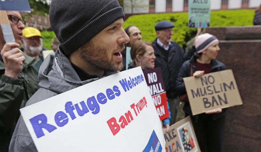 Miles Treakle, left, of Seattle, holds a sign that reads &amp;quot;Refugees Welcome Ban Trump,&amp;quot; as he protests against President Donald Trump&#39;s revised travel ban, Monday, May 15, 2017, outside a federal courthouse in Seattle. A three-judge panel of the 9th U.S. Circuit Court of Appeals heard arguments Monday in Seattle over Hawaii&#39;s lawsuit challenging the travel ban, which would suspend the nation&#39;s refugee program and temporarily bar new visas for citizens of Iran, Libya, Somalia, Sudan, Syria and Yemen. (AP Photo/Ted S. Warren)