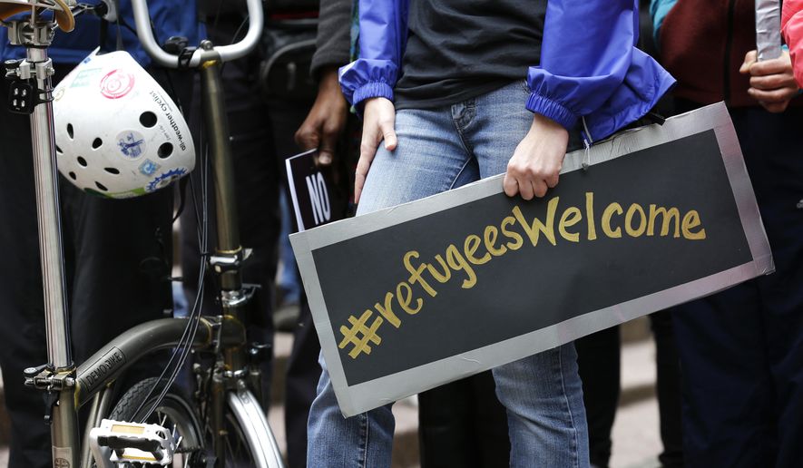 A protester holds a poster with the social media hashtag &amp;quot;#refugeesWelcome,&amp;quot; during a demonstration against President Donald Trump&#39;s revised travel ban, Monday, May 15, 2017, outside a federal courthouse in Seattle. A three-judge panel of the 9th U.S. Circuit Court of Appeals heard arguments Monday in Seattle over Hawaii&#39;s lawsuit challenging the travel ban, which would suspend the nation&#39;s refugee program and temporarily bar new visas for citizens of Iran, Libya, Somalia, Sudan, Syria and Yemen. (AP Photo/Ted S. Warren)