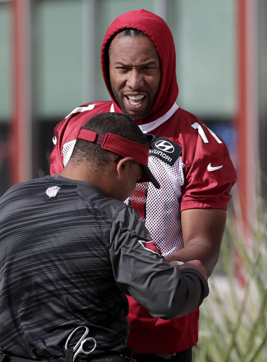 Arizona Cardinals NFL football player Larry Fitzgerald gets his wrist taped during a voluntary team workout, Tuesday, May 16, 2017, in Tempe, Ariz. (AP Photo/Matt York)