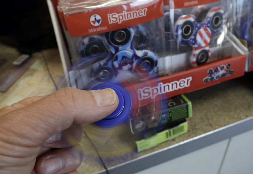 In this Tuesday, May 9, 2017, photo, a fidget spinner toy is used at a 7-Eleven store win Warren, Mich. Stores can’t keep them in stock and parents are going crazy trying to find them. (AP Photo/Carlos Osorio)