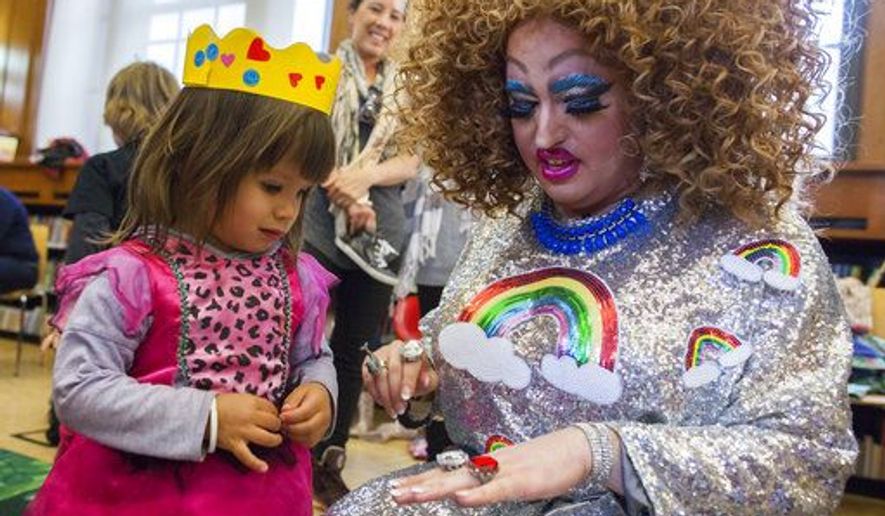 In this Saturday, May 13, 2017 photo, Lil Miss Hot Mess, right, compares outfits with 2-year old Eva McInnes after reading to a group of children during the Feminist Press&#x27; presentation of Drag Queen Story Hour at the Park Slope Branch of the Brooklyn Public Library in New York City. (AP Photo/Mary Altaffer)
