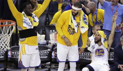 Golden State Warriors&#39; Draymond Green, JaVale McGee and Stephen Curry, from left, celebrate from the bench in the closing minutes of the team&#39;s 136-100 win over the San Antonio Spurs during Game 2 of the NBA basketball Western Conference finals, Tuesday, May 16, 2017, in Oakland, Calif. (AP Photo/Marcio Jose Sanchez)