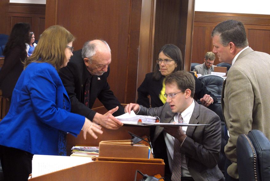 Several Alaska state representatives gather around Rep. Lance Pruitt, seated, during a break in a House floor session on Wednesday, May 17, 2017, in Juneau, Alaska. Shown are, from left, Reps. Tammie Wilson, Steve Thompson, Jennifer Johnston, Pruitt and Chuck Kopp. (AP Photo/Becky Bohrer)