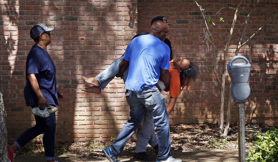 Family members carry a grief stricken Ebony Archie, mother of Kingston Frazier, after learning the young boy was found dead after being kidnapped during the theft of his mother's vehicle from a Kroger parking lot, Thursday, May 18, 2017, in Jackson, Miss. (Elijah Baylis/The Clarion-Ledger via AP)