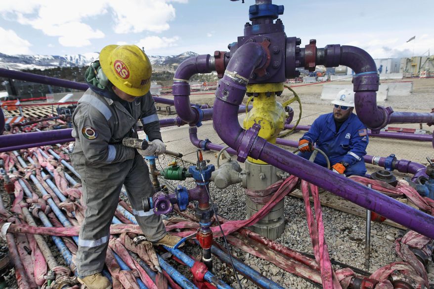 Workers tend to a well head during a hydraulic fracturing operation outside Rifle, in western Colorado on March 29, 2013. (Associated Press) **FILE**