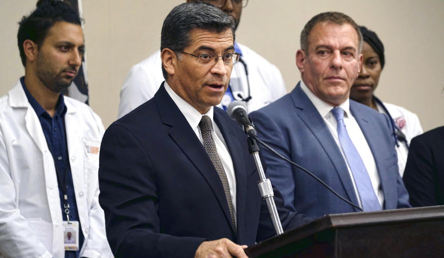 Jim Mangia, CEO of St. John&#x27;s Well Child and Family Center, right watches as California Attorney General Xavier Becerra talks during a news conference at St. John&#x27;s Well Child and Family Center in Los Angeles on Thursday, May 18, 2017. Becerra announced legal steps to protect billions of dollars to provide health care under the Affordable Care Act, in another battlefront with the Trump White House. (AP Photo/Richard Vogel)