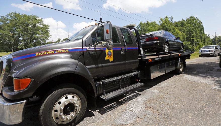 A Mississippi Highway Patrol tow truck hauls away a vehicle from a dead end road in Gluckstadt, Miss., Thursday morning, May 18, 2017, where 6-year-old Kingston Frazier was shot to death after the car he was riding in was stolen early, from a grocery store parking lot in Jackson. (AP Photo/Rogelio V. Solis)