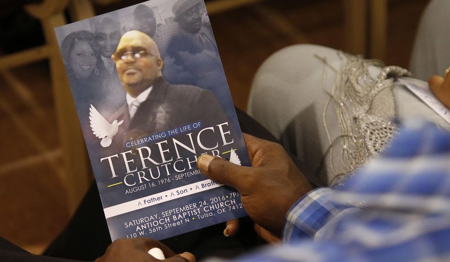 FILE - In this Sept. 24, 2016 file photo, a man holds a copy of the program for the funeral of Terence Crutcher during services to honor him in Tulsa, Okla., Crutcher was fatally shot Sept. 16 by Tulsa Police Officer Betty Shelby. A jury on Wednesday, May 17, 2017, found Shelby not guilty in Crutcher&#x27;s death. His death was among a series across the U.S. involving black people in recent years that spurred a national debate over race and policing. (AP Photo/Sue Ogrocki File)