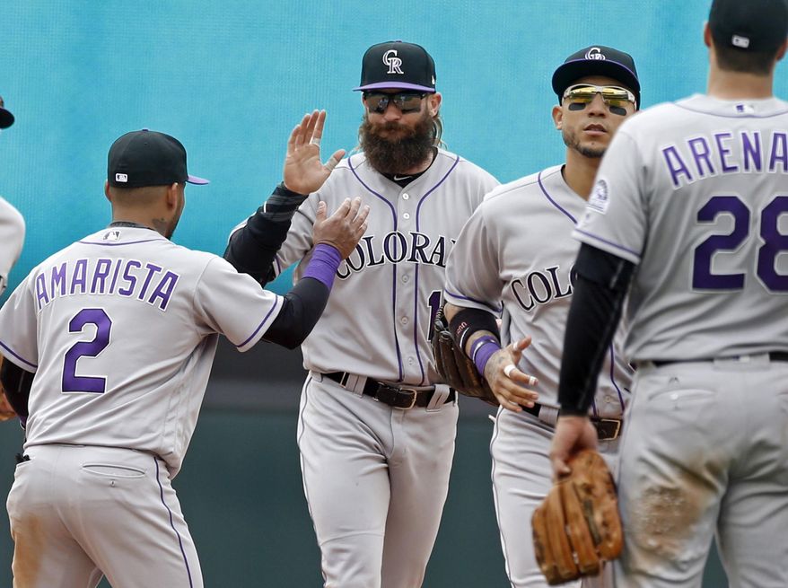 Colorado Rockies' Alexi Amarista, left, high-fives Charlie Blackmon after the Rockies beat the Minnesota Twins 5-1 in the first baseball game of a doubleheader, Thursday, May 18, 2017 in Minneapolis. (AP Photo/Jim Mone)