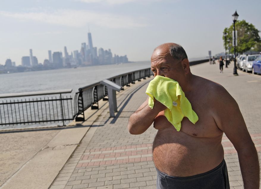 Ed Tirone takes a break from reading on the pier to wipe a wet washcloth over his face in Hoboken, N.J., Thursday, May 18, 2017. Forecasters say temperatures across the state could reach the above 90 degrees on Thursday and the trend is expected to continue through Friday. (AP Photo/Seth Wenig)